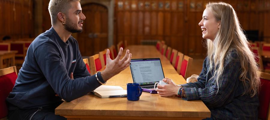 Two students chatting and working in Rainy Hall